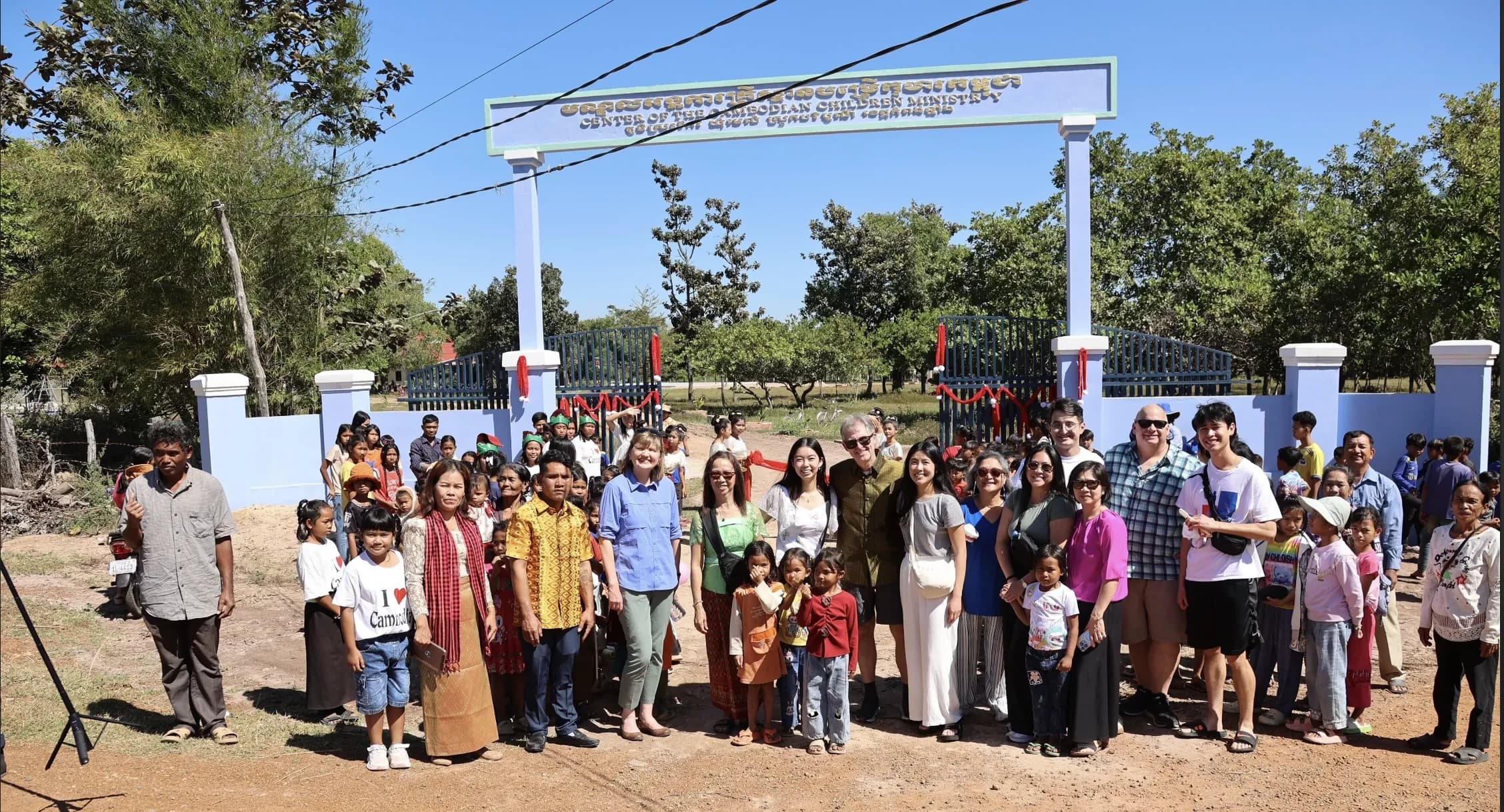 Mission trip team with children and families at the gate of the Center of the Cambodian Children Ministry